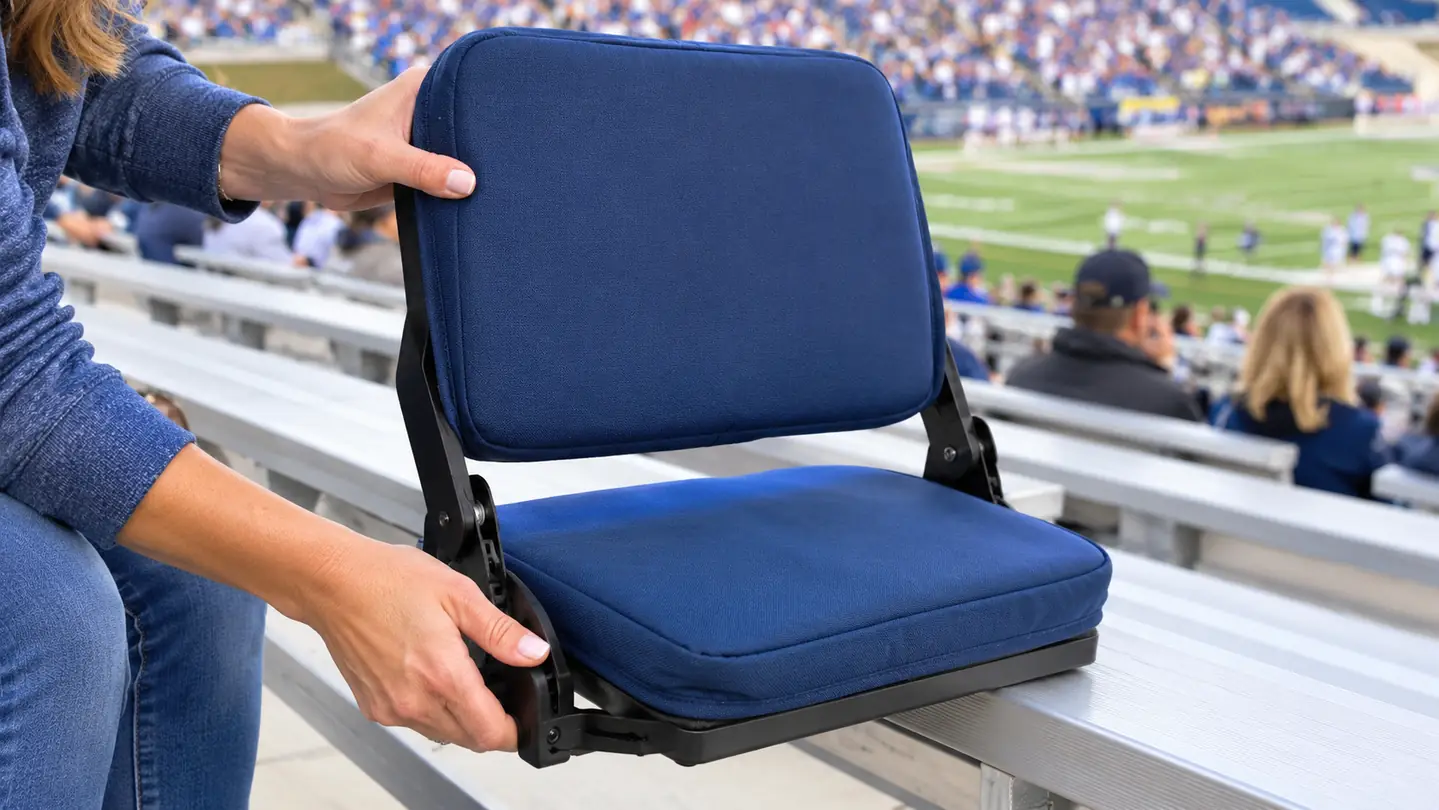 Hands adjusting a stadium seat with back support on a bleacher